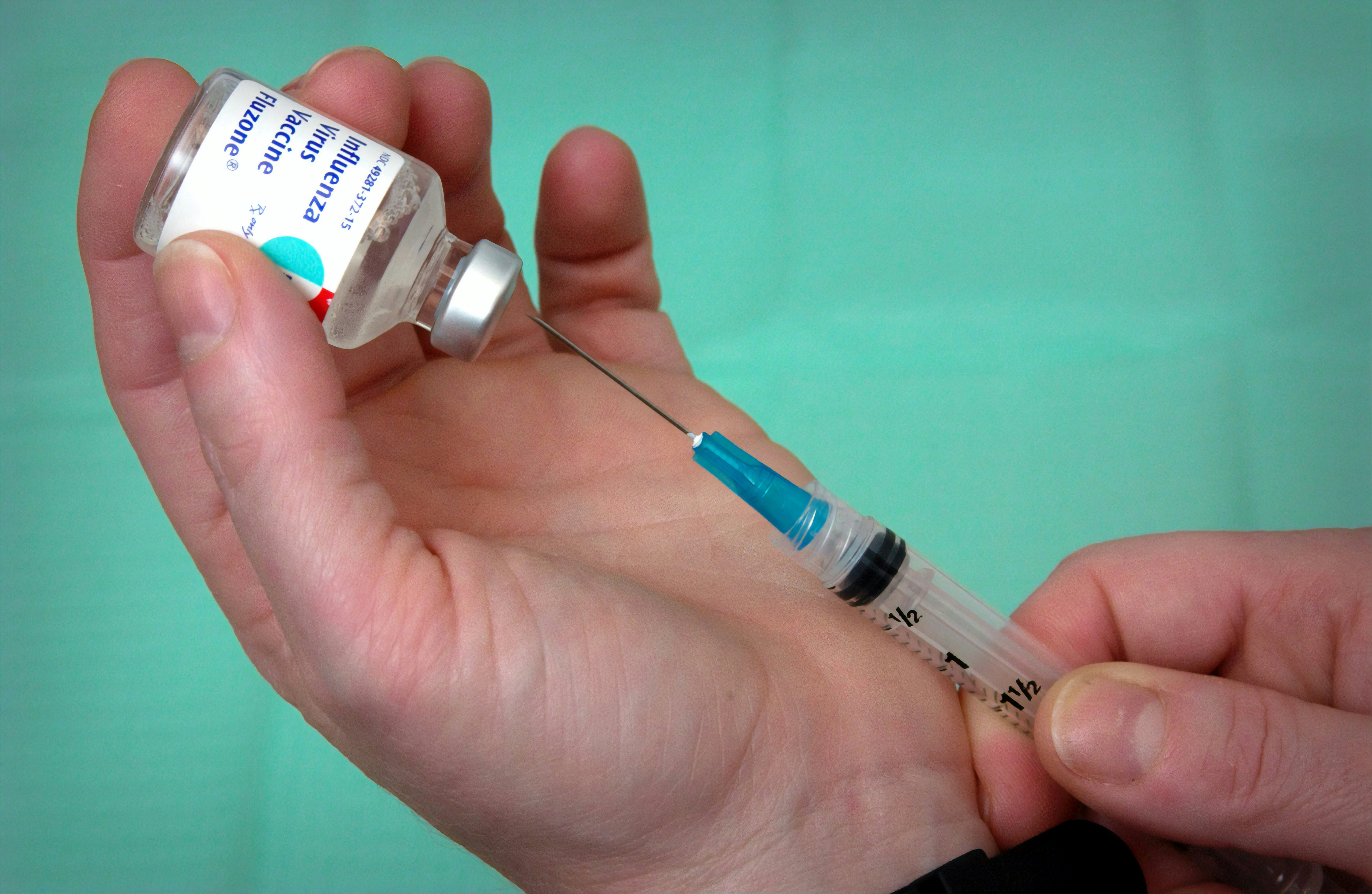 person holding syringe and vial